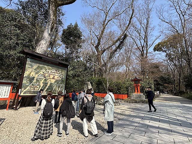 下鴨神社参道入口付近で、案内図に見入る参加者たち